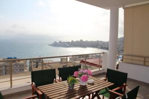 a table on a balcony with a view of the ocean at Nefeli Apartments in Sarandë