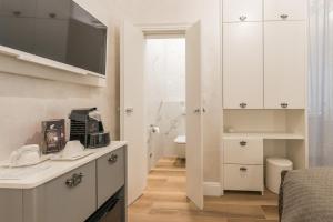 a white bathroom with a sink and a toilet at Zara Palace - design rooms in Zadar