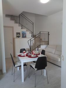 einen weißen Tisch und Stühle im Wohnzimmer in der Unterkunft Eryx Apartments in Trapani
