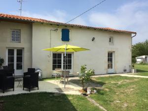 a yellow umbrella in front of a house at Tess Cottage in Brie-sous-Mortagne