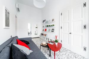 - un salon avec un canapé gris et une table rouge dans l'établissement mrg home holiday, à Sorrente
