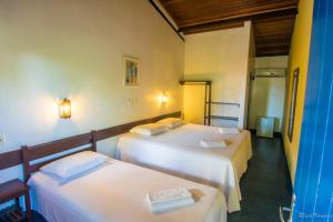 two beds in a room with two beds sidx sidx sidx sidx at Pousada Sao Luiz in Porto Seguro