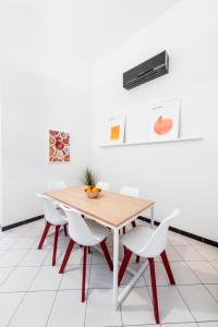 une salle à manger avec une table en bois et des chaises blanches dans l'établissement mrg home holiday, à Sorrente
