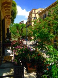 a street with some flowers and trees and buildings at A Casa di Amelie in Palermo