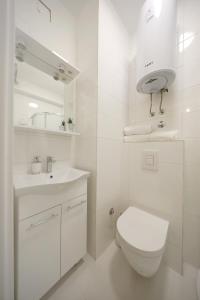 a white bathroom with a toilet and a sink at Apartments and a Room Ina in Zadar +69 photos