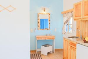 kuchnia z niebieskimi ścianami, umywalką i lustrem w obiekcie Sofia´s rooms w mieście Kyra Panagia