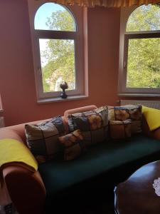 a living room with a couch and two windows at Haus Andrea in Wernigerode