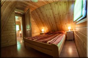 a bedroom with a bed in a wooden room at CUBA domki letniskowe in Sarbinowo