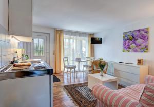 a kitchen and a living room with a couch and a table at Ferienwohnung Grams in Lassan