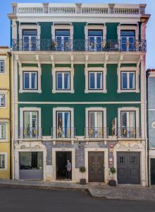 a green building with a man standing in front of it at Quinta Colina by Shiadu in Lisbon