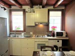 uma cozinha com armários brancos, um lavatório e um micro-ondas em icalderai em Palermo