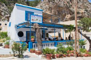 niebiesko-biały budynek z ludźmi siedzącymi na balkonie w obiekcie Sofia´s rooms w mieście Kyra Panagia