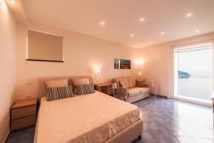 una camera da letto con un letto, un divano e una finestra di Le Esperidi a Ravello