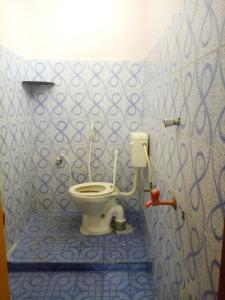 a bathroom with a toilet in a blue tiled wall at Villa Bonny Home Stay in Puducherry
