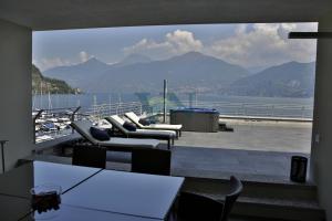 einen Balkon mit Stühlen und Blick auf das Wasser in der Unterkunft Villa Navalia in Menaggio