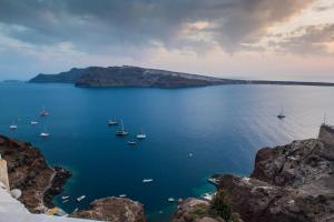 a view of a large body of water with boats at Hyperion Oia Suites in Oia