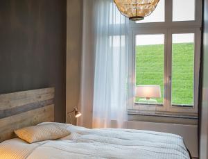 a bedroom with a bed and a window at Seaside Apartments Austernbank in Cuxhaven