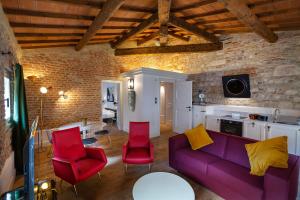 ein Wohnzimmer mit einem lila Sofa und roten Stühlen in der Unterkunft Residenza Palazzo Brenzoni in Verona