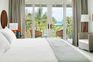 a bedroom with a bed and a view of the ocean at Couples Negril in Negril