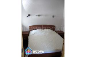a bed in a small room with a white mattress at Apartmani Katarina in Budva