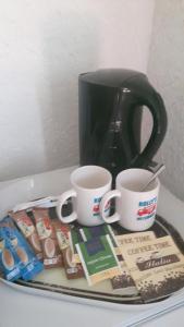 a tray with two cups and two coffee mugs at Motel Route 216 in Göhrde
