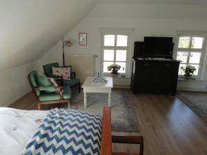 a living room with a bed and a tv at Alte Pastorei in Hinte