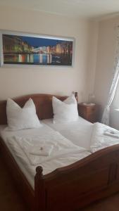 1 dormitorio con 1 cama con sábanas y almohadas blancas en Motel Route 216, en Göhrde