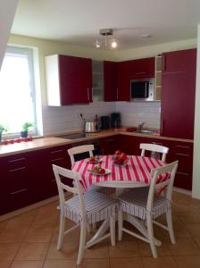 uma cozinha com uma mesa com uma toalha de mesa vermelha e branca em Haus Am Strom 50 em Warnemünde