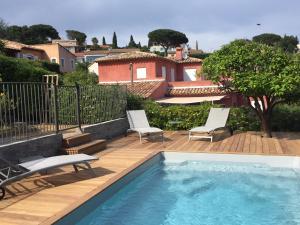 a swimming pool on a deck with two chairs at Villa Heliomar in Cavalaire-sur-Mer