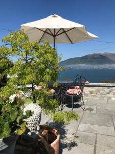 a patio with a table and an umbrella and some plants at Carlingford Sea Cottage in Carlingford