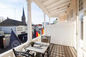 eine Terrasse mit einem Tisch und Stühlen auf dem Balkon in der Unterkunft Hotel XL in Zandvoort