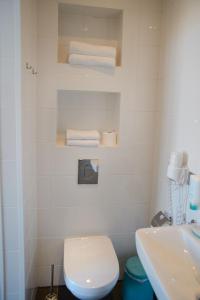a bathroom with a toilet and a sink and towels at Hotel XL in Zandvoort