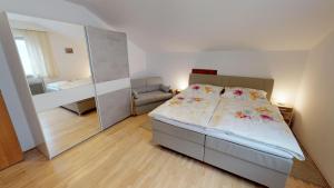 a bedroom with a large bed and a mirror at Ferienwohnung Pirker in Spittal an der Drau