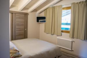 una piccola camera da letto con un letto e una finestra di Agriturismo Ruc del Lac a Boario Terme