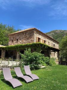 three lounge chairs in front of a stone building at A Muvrella in Pioggiola