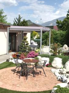 eine Terrasse mit einem Tisch und Stühlen im Garten in der Unterkunft B&B à la Madeleine in Vétroz