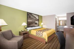 une chambre d'hôtel avec un lit et une chaise dans l'établissement Super 8 by Wyndham Springdale AR, à Springdale