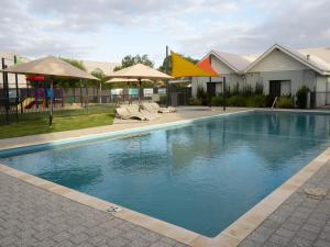 a large swimming pool with chairs and umbrellas at FortyOne - Oceanside Retreat Busselton in Busselton