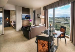 Absolute Hotel Limerick في ليميريك: غرفة في الفندق مع مكتب وسرير وغرفة