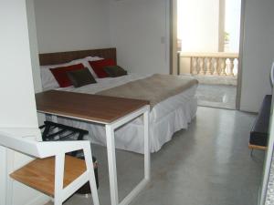 a bedroom with a bed and a table and a window at The Sancy in Rosario