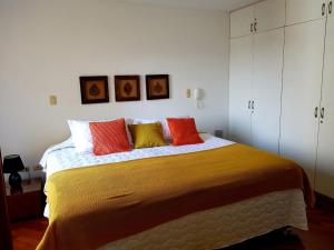 - une chambre avec un grand lit et des oreillers colorés dans l'établissement Malecón, à Lima