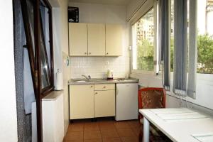 a kitchen with white cabinets and a sink and a window at Apartments Milena & Ante in Makarska