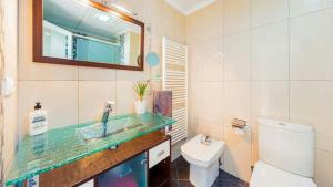 a bathroom with a sink and a toilet and a mirror at La Mata Beach Apartment in La Mata +32 photos