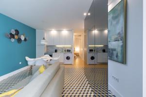 een woonkamer met een witte bank en een keuken bij Porto Blue Terrace in Porto