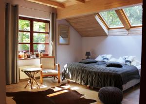 カルパチにあるGórska Rezydencjaのベッドルーム1室(ベッド1台、テーブル、窓付)