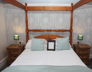 a bedroom with a bed with a wooden head board at Kirkwood Guest House in Windermere