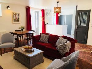 PlurienにあるManoir des Cognetsのリビングルーム(赤いソファ、テーブル付)