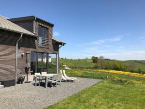 a patio with a table and chairs next to a house at Ferienhaus am Nationalpark in Morsbach