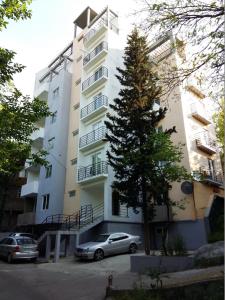 a building with cars parked in front of it at Busas Apartment in Tbilisi City