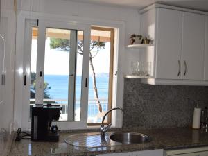 サン・フェリウ・デ・ギホルスにあるApartament senya salvi baixosの海の景色を望むキッチン(シンク付)